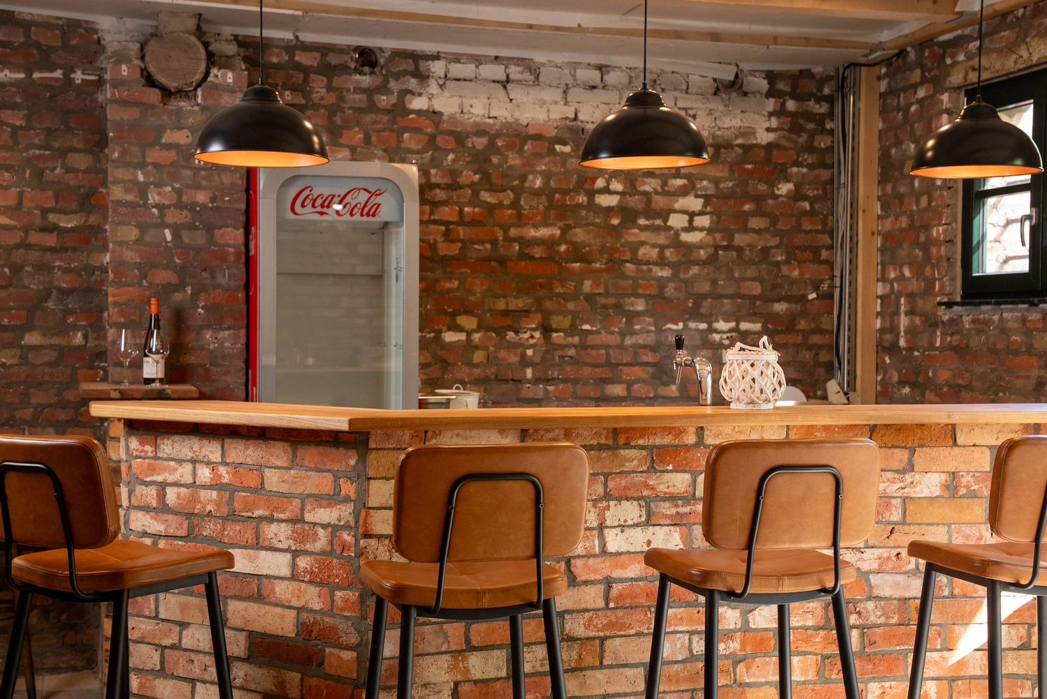 Alpakahof Dingen – Alpaka-Trekking – Das Bild zeigt eine ländliche Bauernhofszene mit Alpakas in einem hölzernen Unterstand und Gehege.