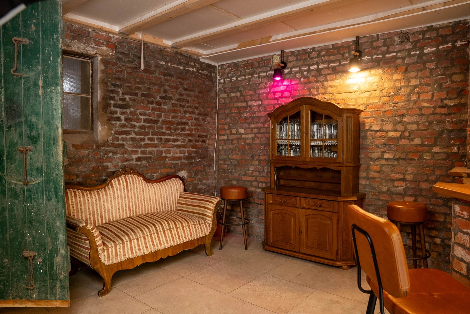 Alpakahof Dingen – Alpaka-Trekking – Das Bild zeigt eine ländliche Bauernhofszene mit Alpakas in einem hölzernen Unterstand und Gehege.